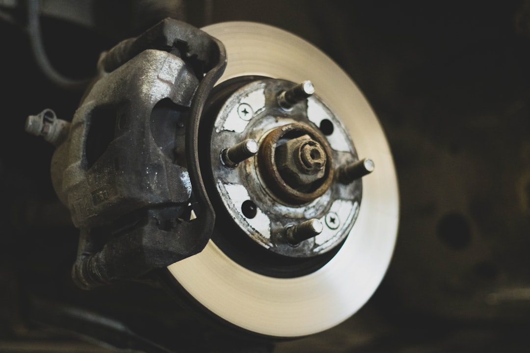 Gros plan sur des plaquettes de frein usées et un disque de frein dans une roue de voiture